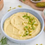 dill pickle hummus serve in a blue bowl.