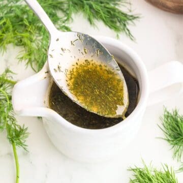 dill salad dressing in a small white bowl with a spoon.