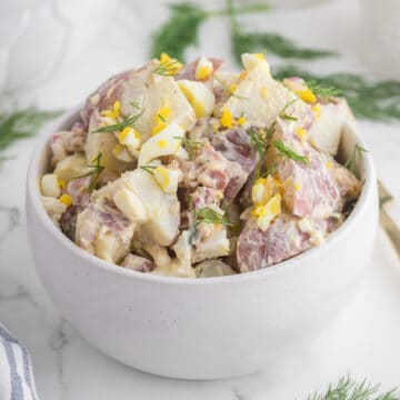 red skin potato salad serve in a white bowl