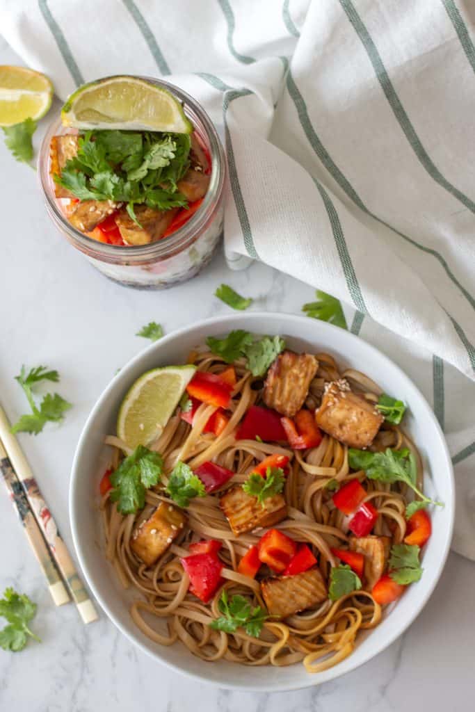 Tofu Vegan Drunken Noodle in a bowl with Mason Jar in the back top view