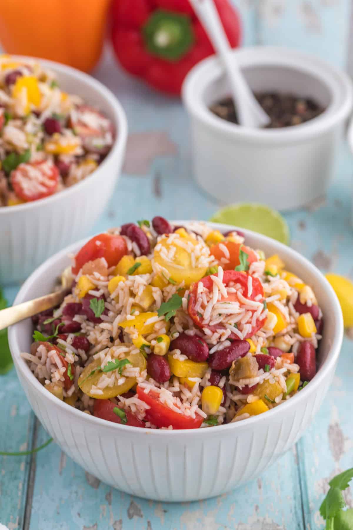 Cold Mexican Rice Salad serve in a white bowl with a spoon.