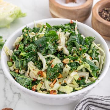 Kale Salad serve in a white bowl.