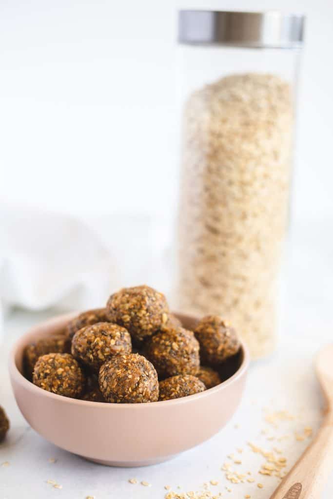 The energy balls on a smalls bowl  with oats in the background