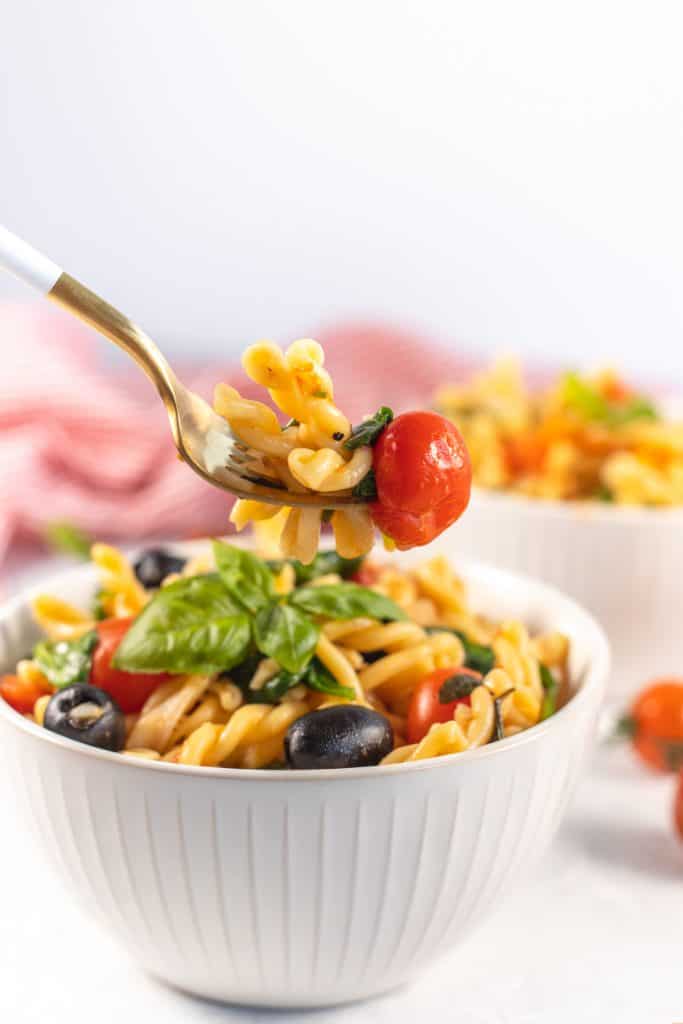 cooked pasta with cherry tomato on a fork