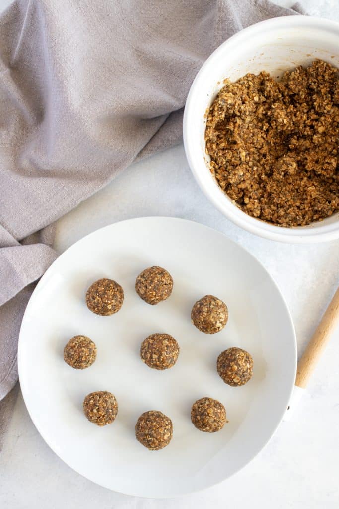 The bowl with the ingredients mixed and energy balls on the sides 