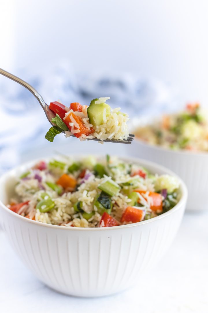 Bowl of basmati rice salad with a spoon full of salad 