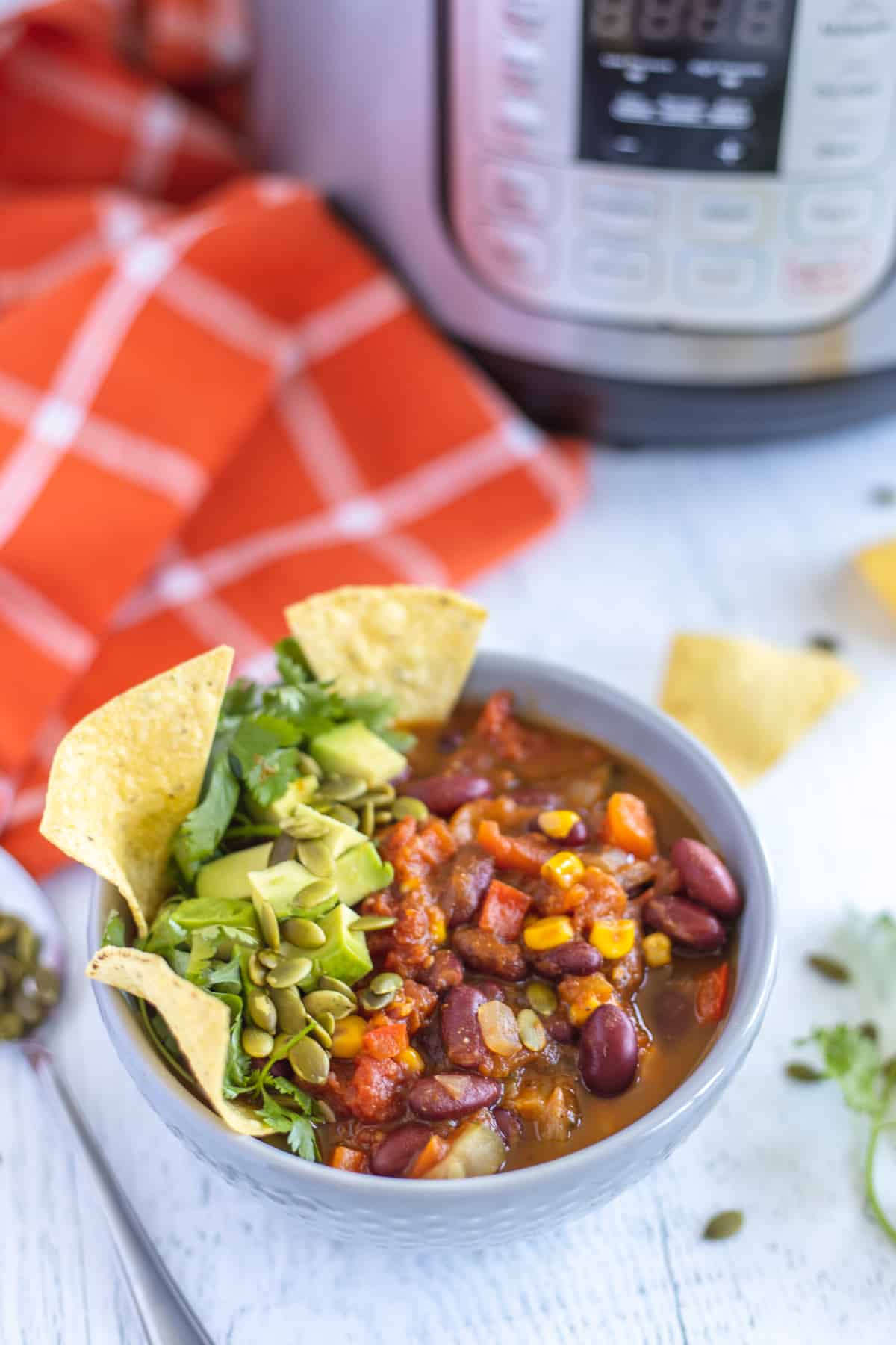 Instant Pot Vegan Pumpkin Chili in a grey bowl with tortillas chip on top 