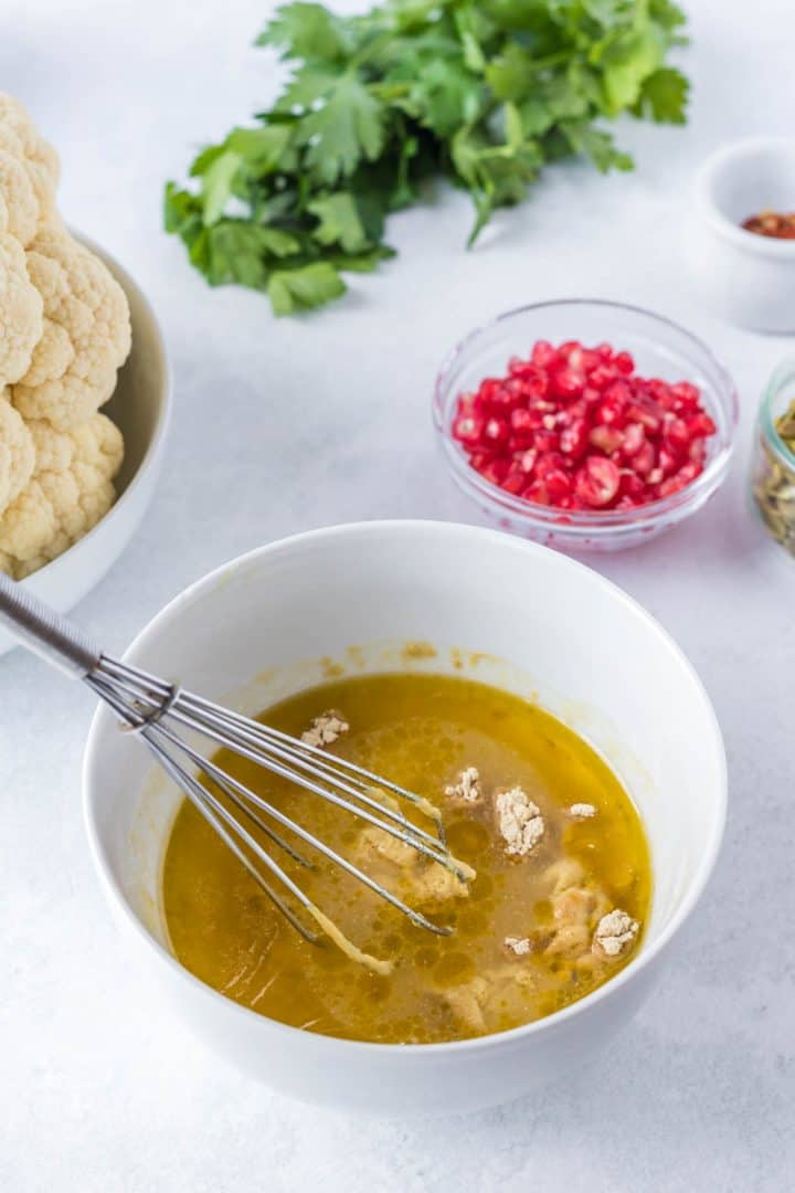 Mixing the sauce in a small white bowl.