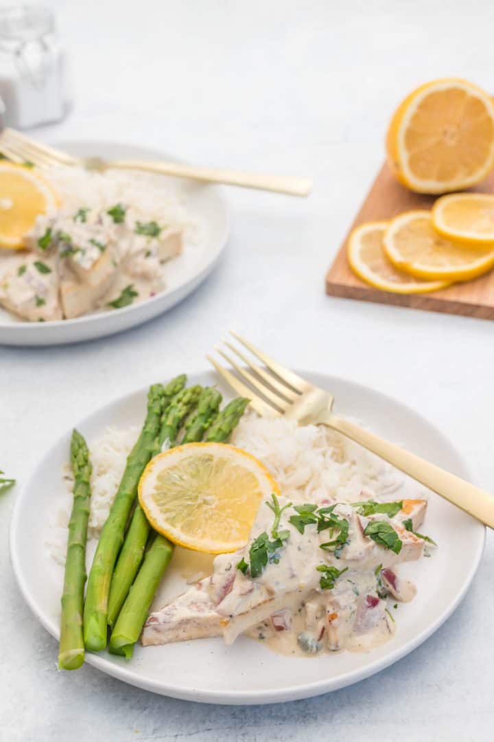 Pan-Fried Tofu with Creamy Lemon Sauce in a white plate serve with rice and asparagus