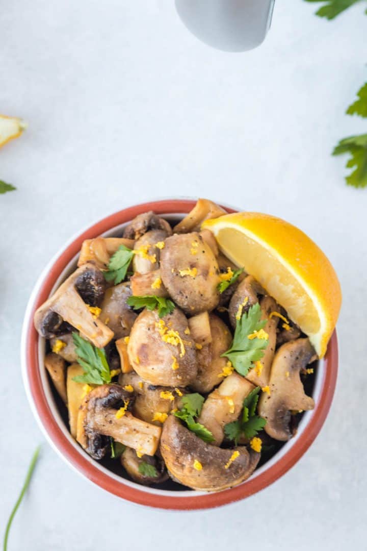 Top view of the serve mushroom with lemon zest and parsley to top.