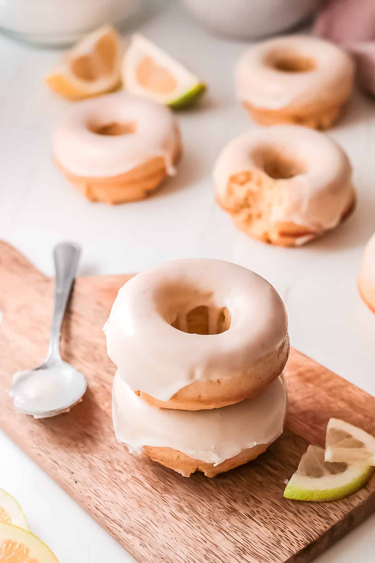 lemon donut on a small wooden cutting board with a spoon