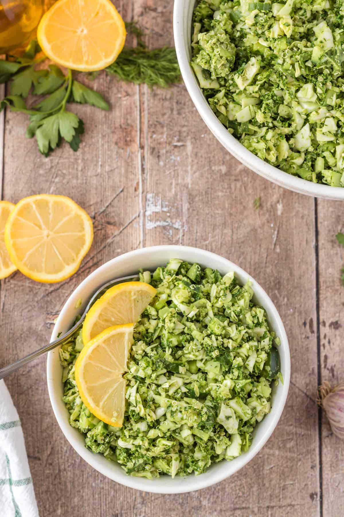 Green goddess salad in a white bowl with lemon slices