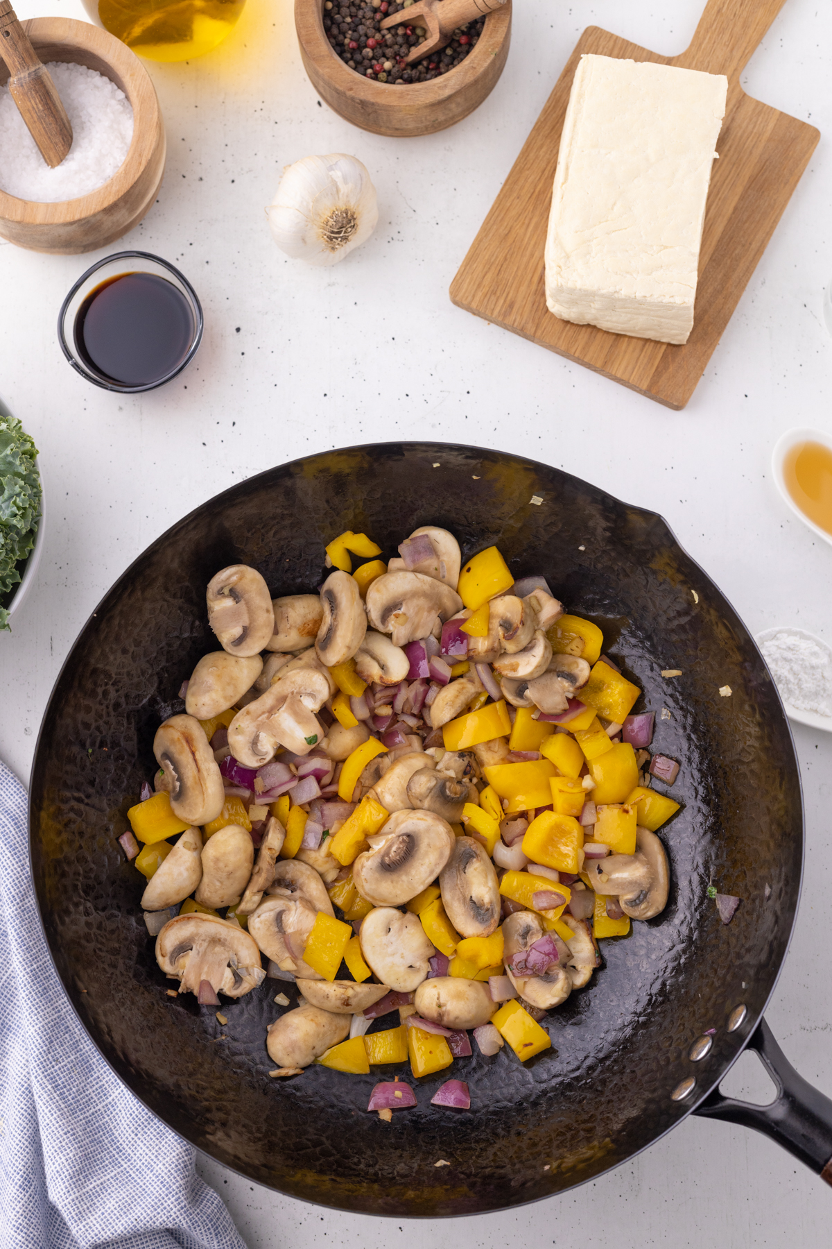 Mushroom, onion and pepper in a wok.