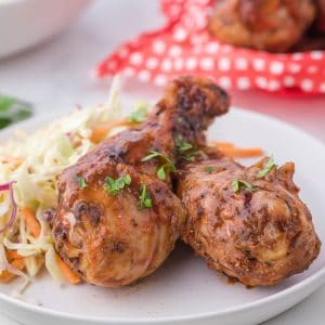 Chicken Drumsticks in a white place with coleslaw close up
