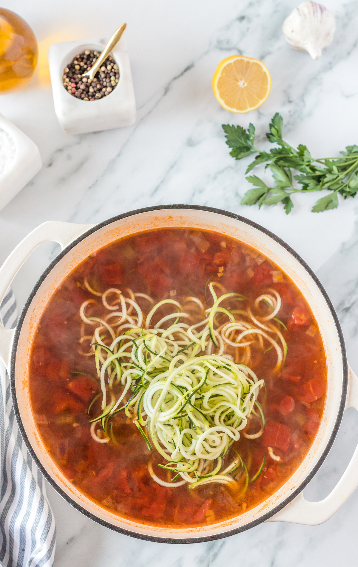 Soup in a pot with the zucchini on top.