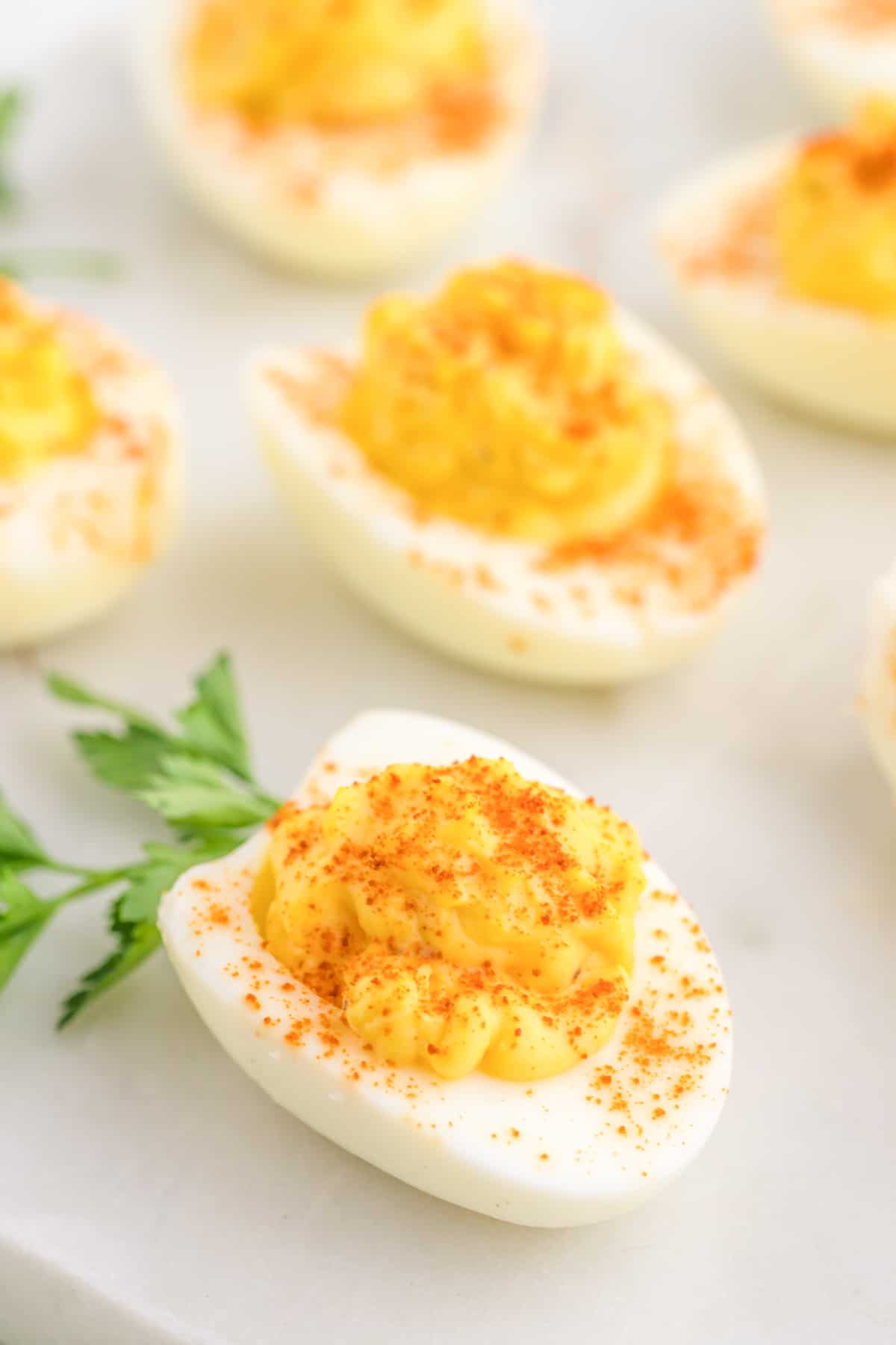 Air fryer deviled egg ready, sprinkle with paprika close up.