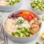 Chicken gyro bowl serve with tomatoes, cucumber, olive, rice and feta.
