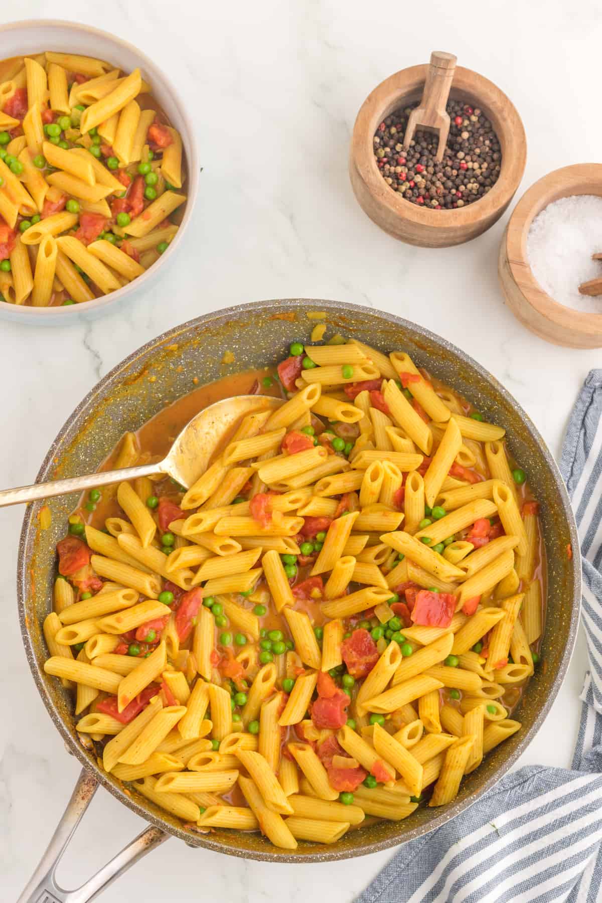 Curry pasta ready in the pan with a serving spoon.