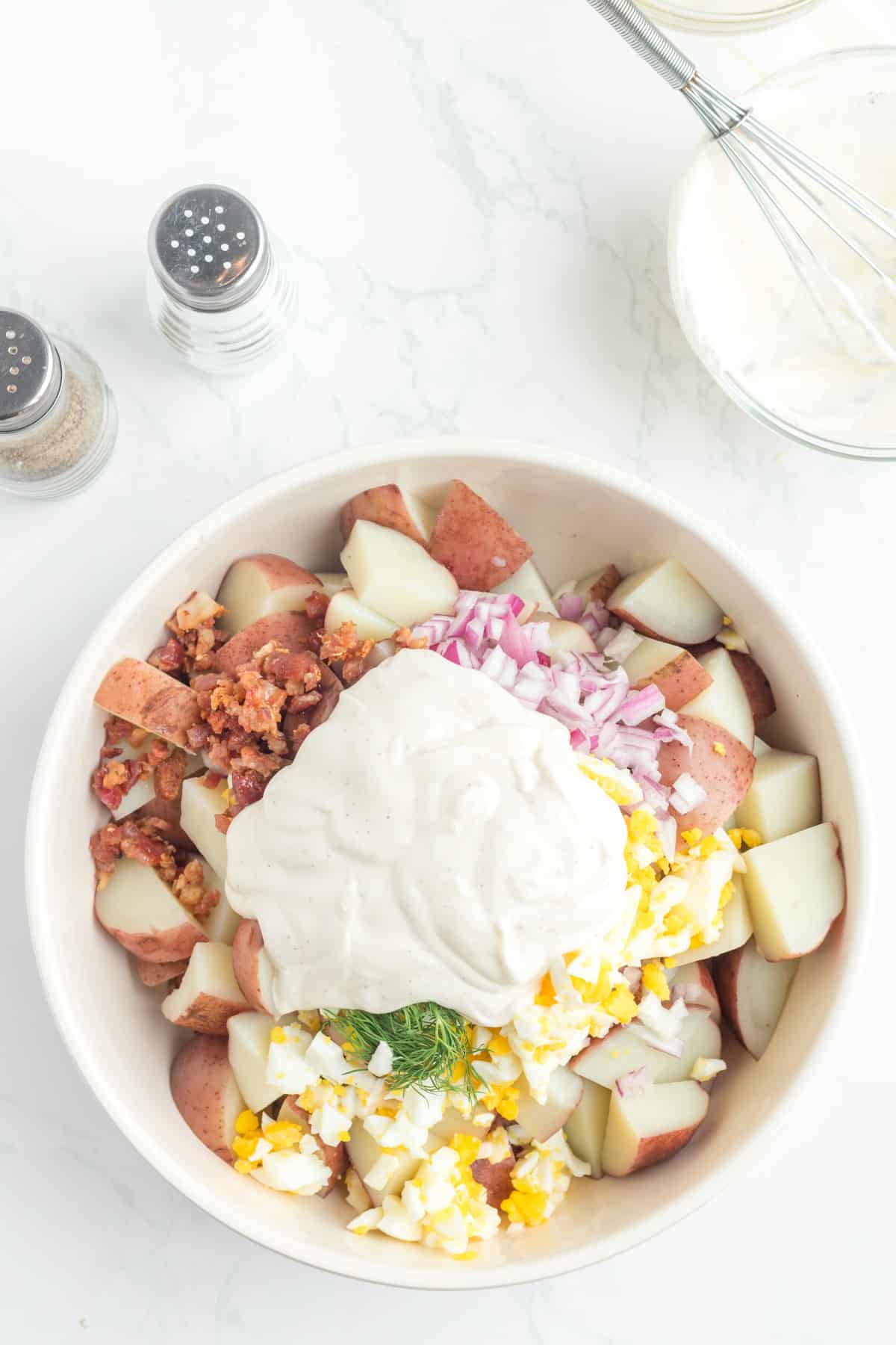 Adding the dressing to the potato salad,