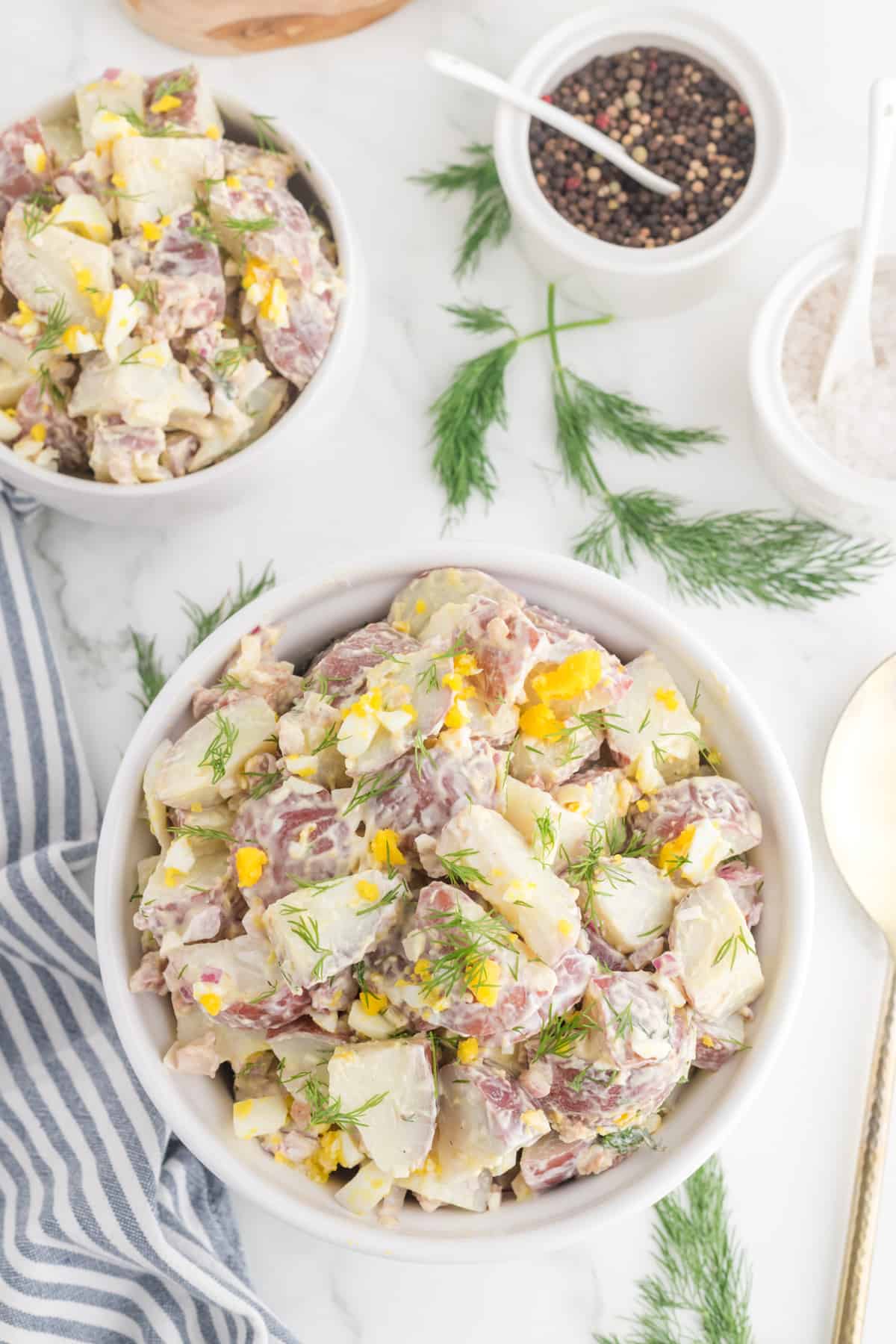 red skin potato salad serve in a white bowl.