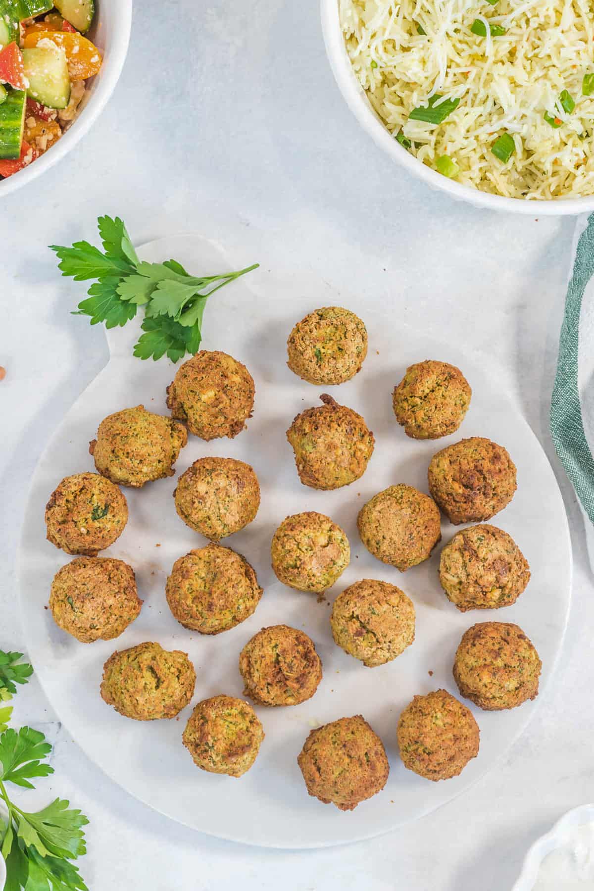 Cooked falafel on a white plate tip view.