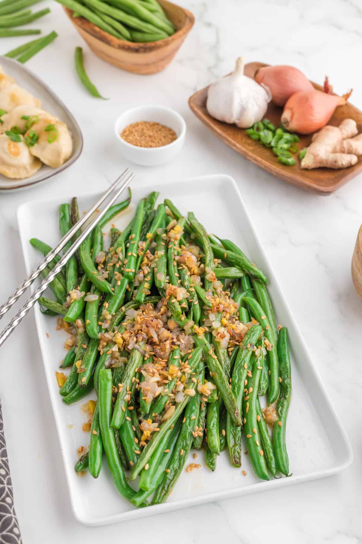 Easy Chinese Green Beans (Din Tai Fung Style) serve in a white serving plate with chopsticks. 