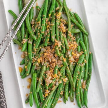 Easy Chinese Green Beans (Din Tai Fung Style) serve in a white serving plate with chopsticks. Top view.