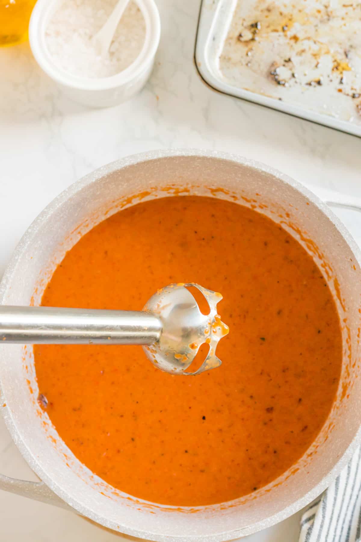 Immersion blender on top of the pot, to blend the ingrediients of the bisque