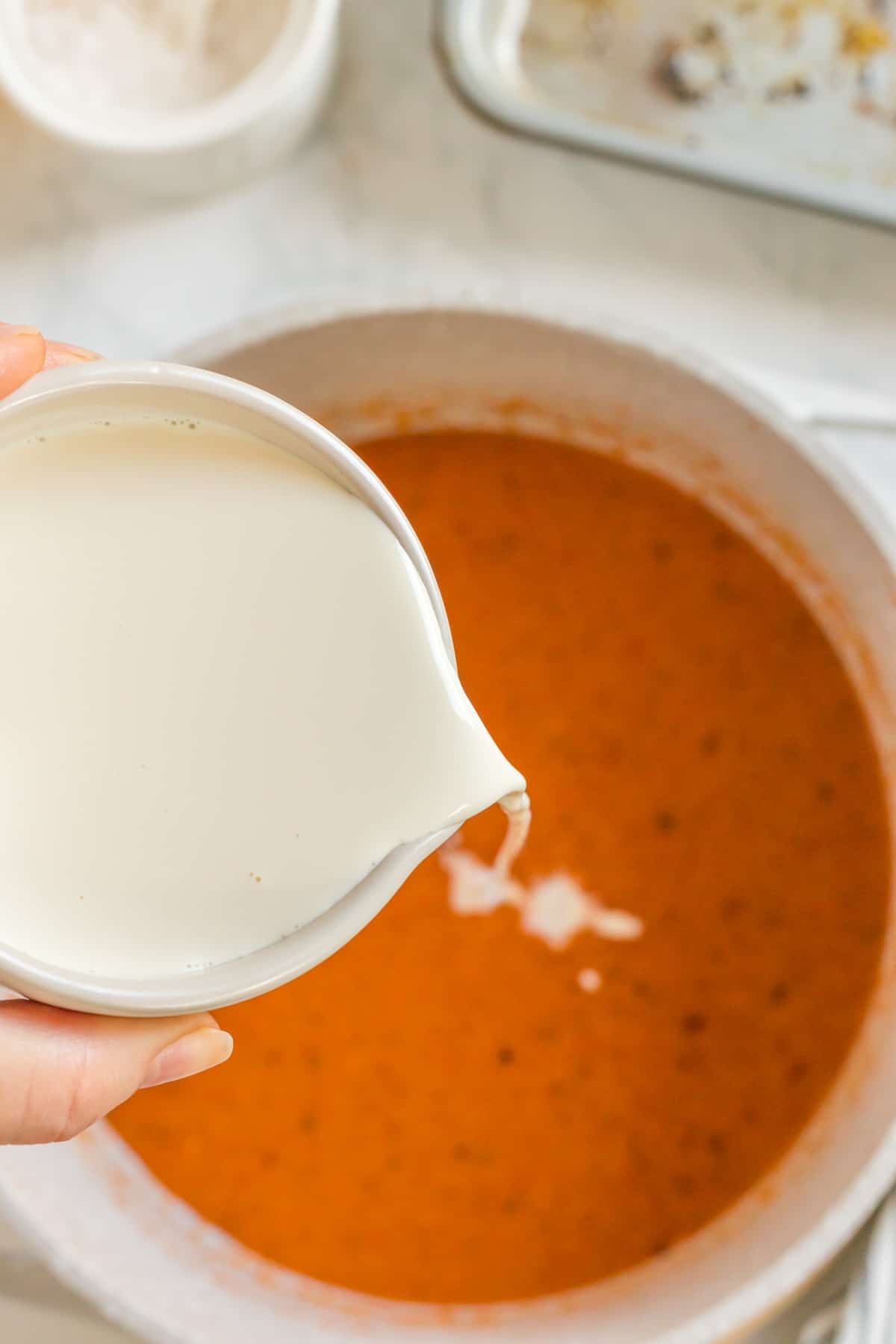 pouring the cream into the soup.