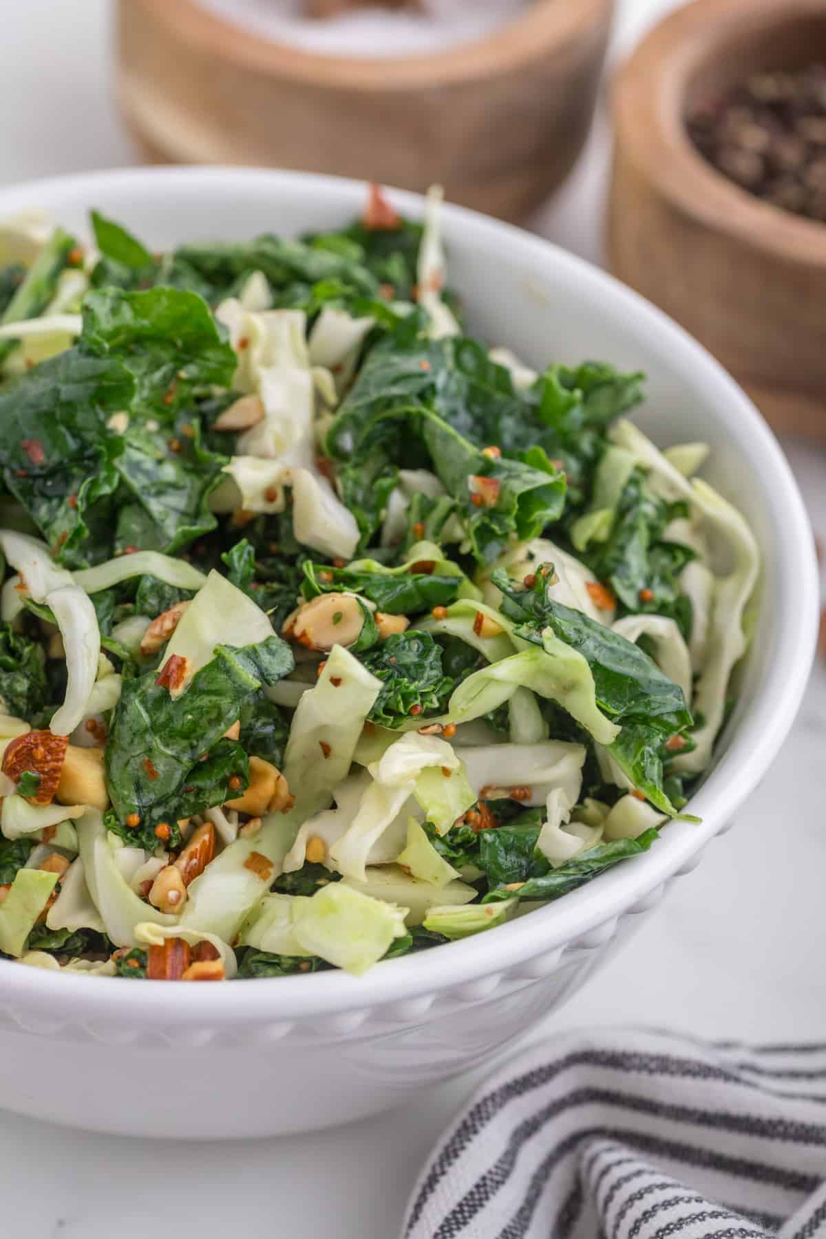 Kale crunch salad serve in a white bowl, close up.