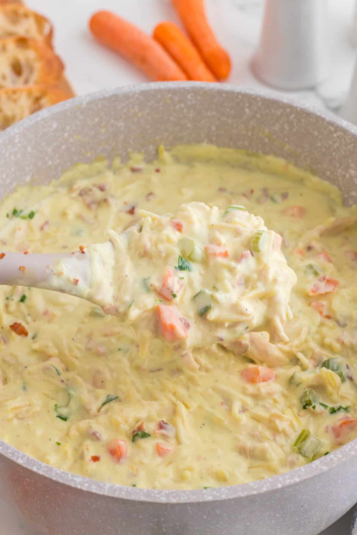 Close up on a ladle of the  Crack chicken noodle soup.