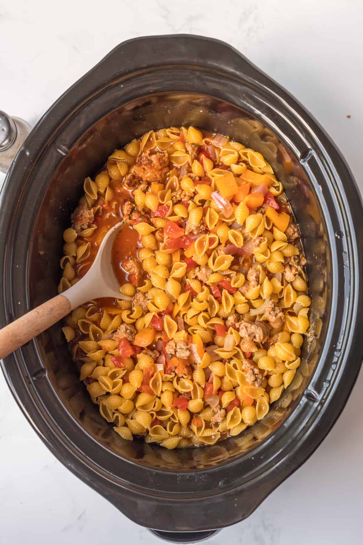 adding the pasta to the crockpot.