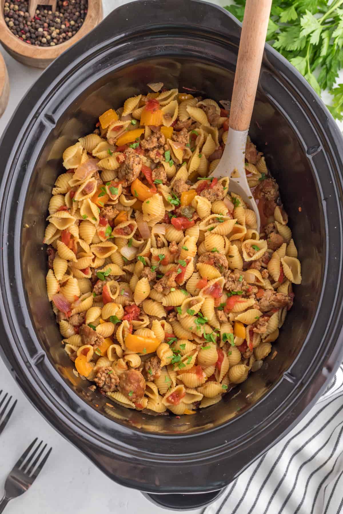 Ground Pork Slow Cooker Casserole still in the slow cooker with a serving spoon.