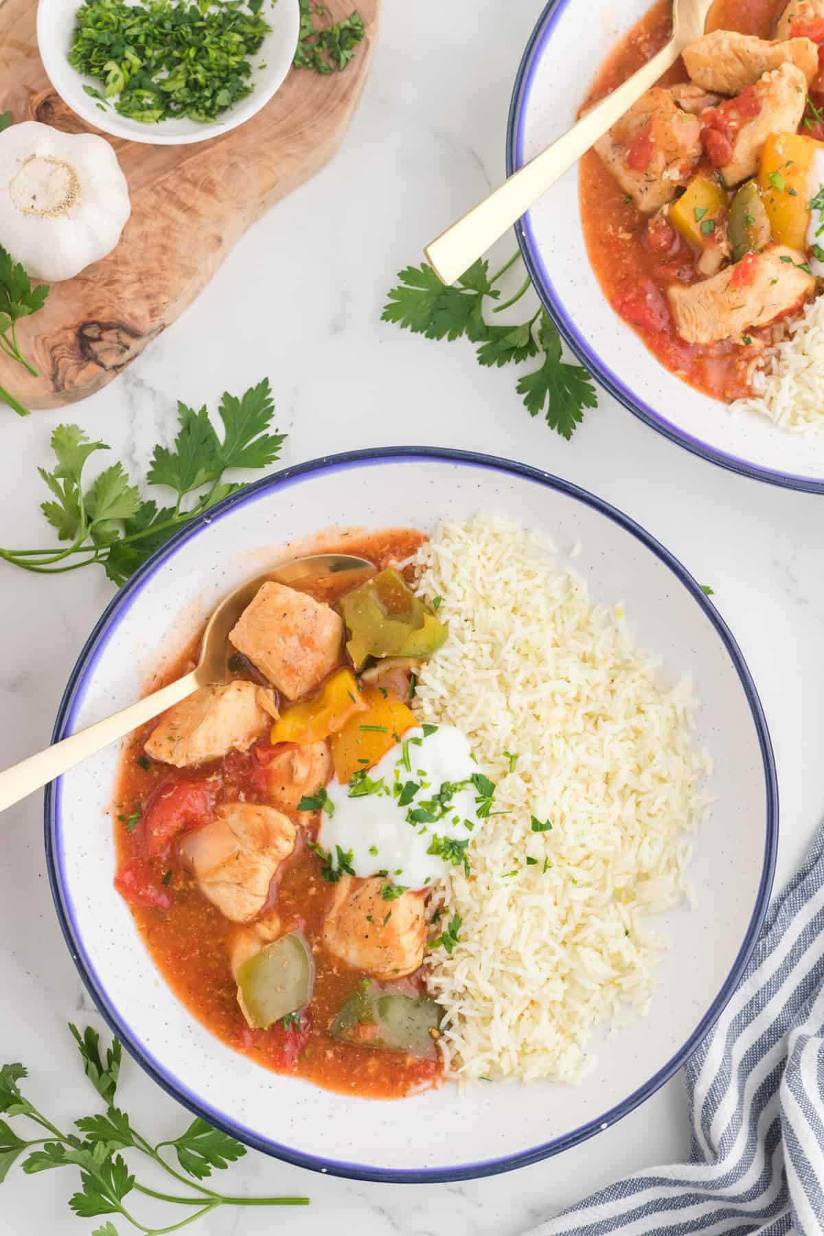Chicken Goulash serve in a bowl with rice and a spoon.