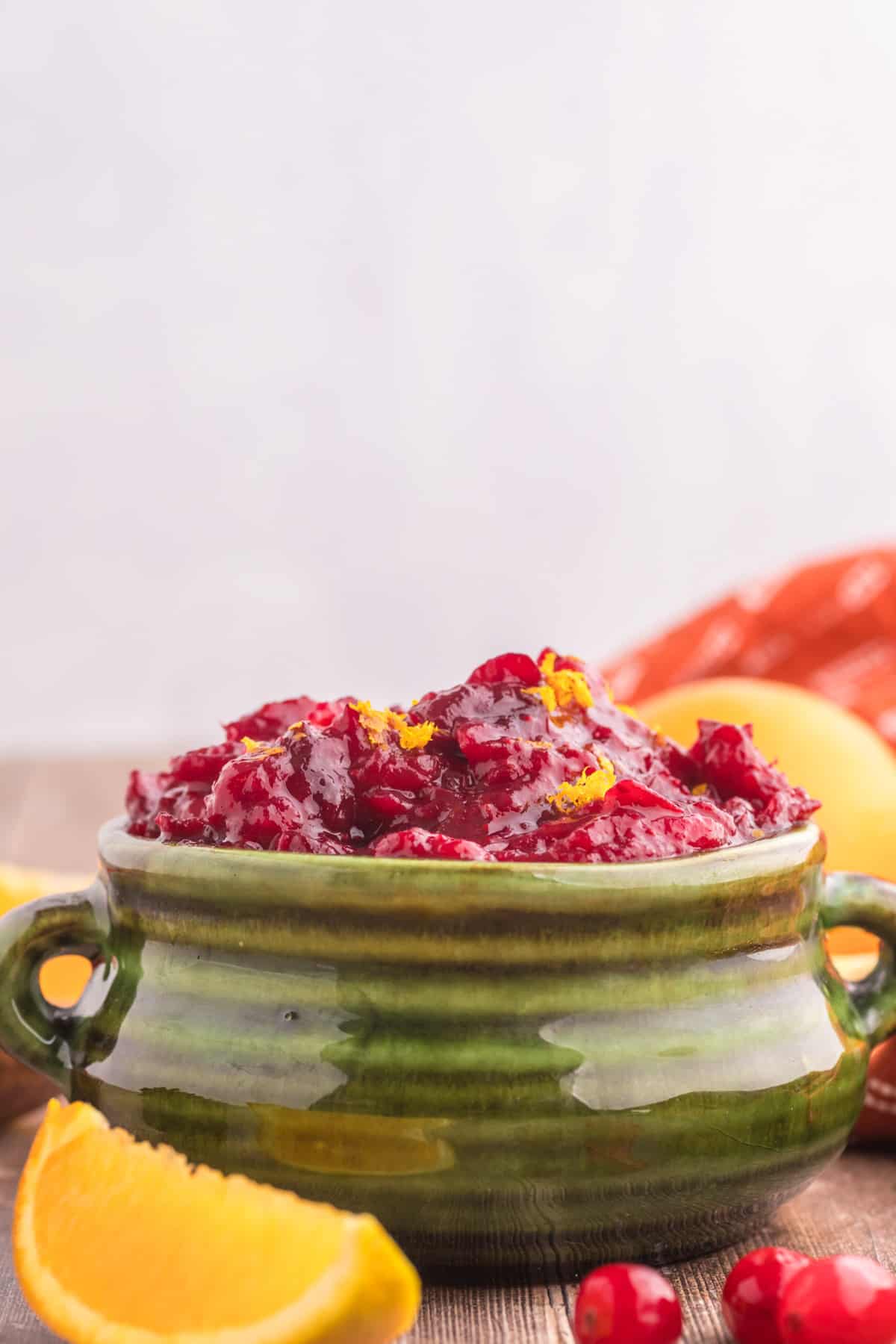 The green bowl holds a flavorful cranberry sauce.