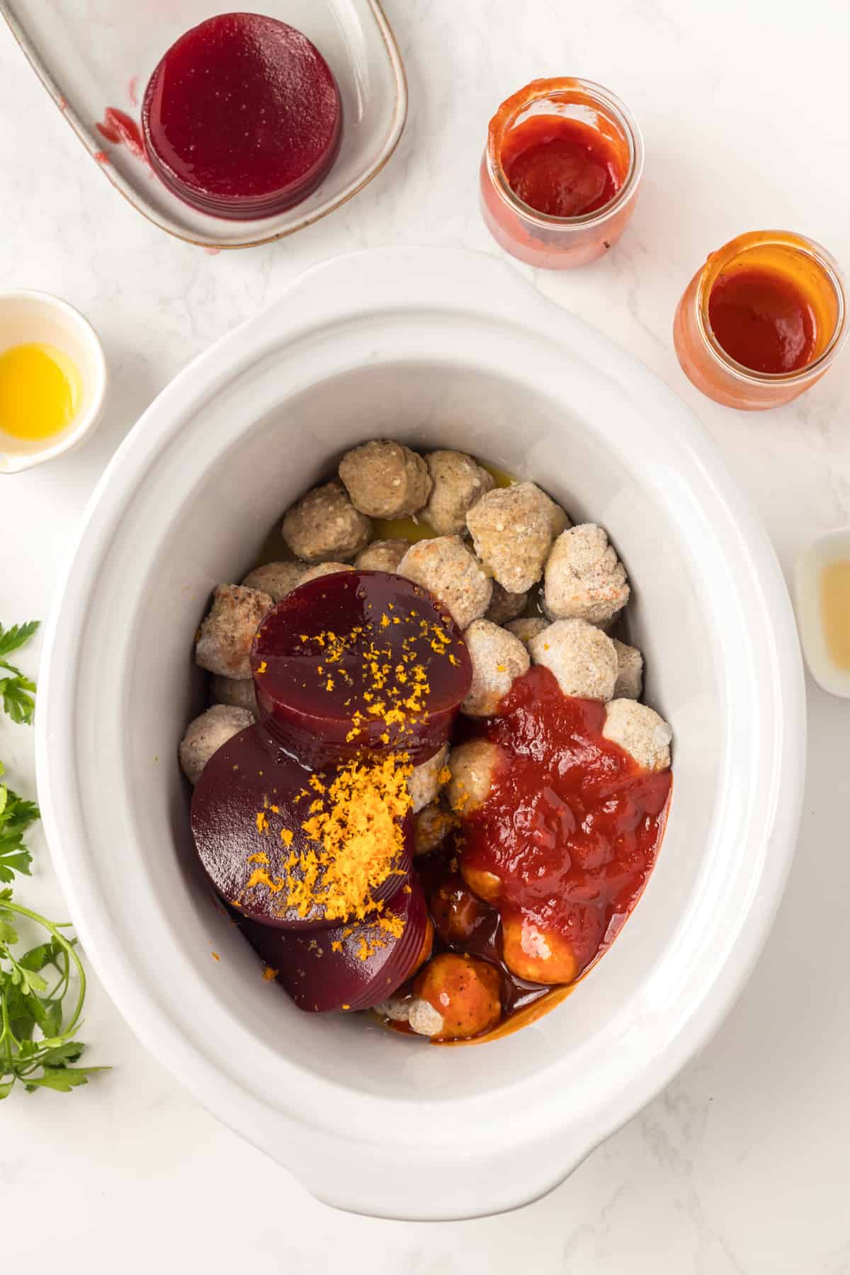 Adding the other ingredients on top of the frozen meatballs.