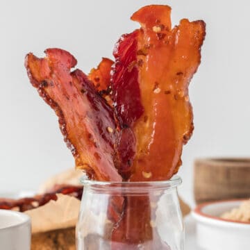 cooked bacon in a glass jar.