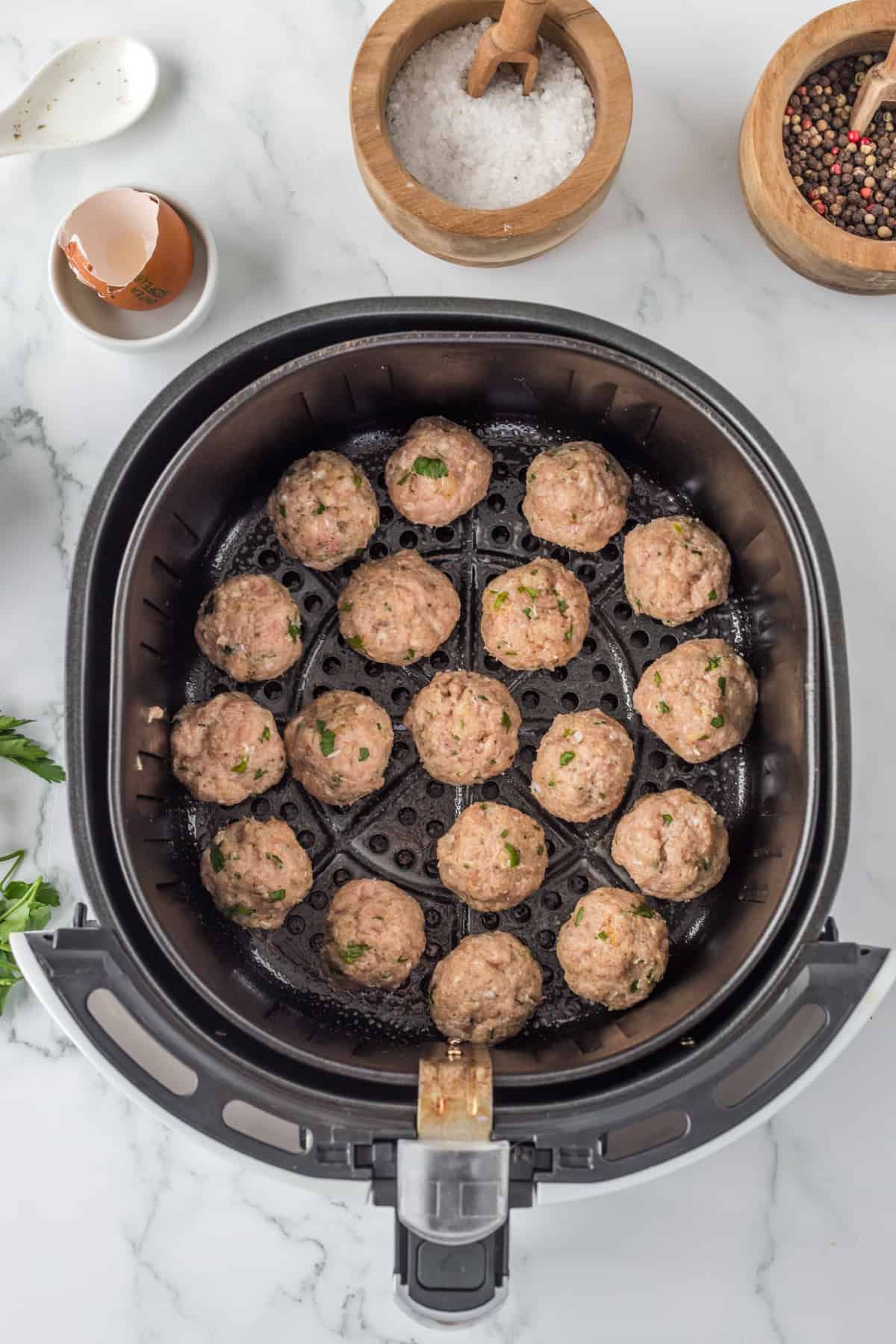 uncooked meatball in the basket of the air fryer