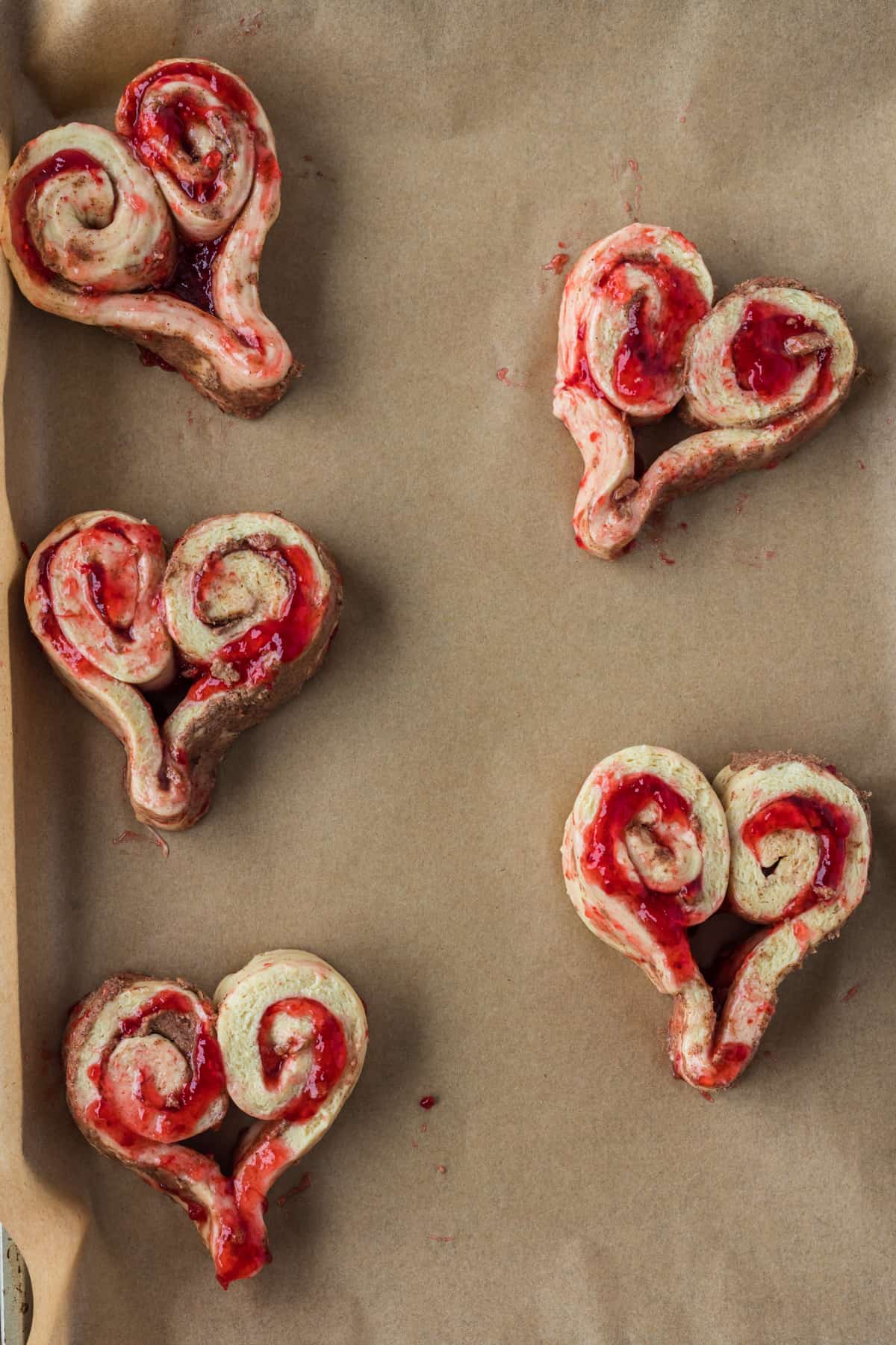 Uncooked cinnamon rolls on the baking sheet.