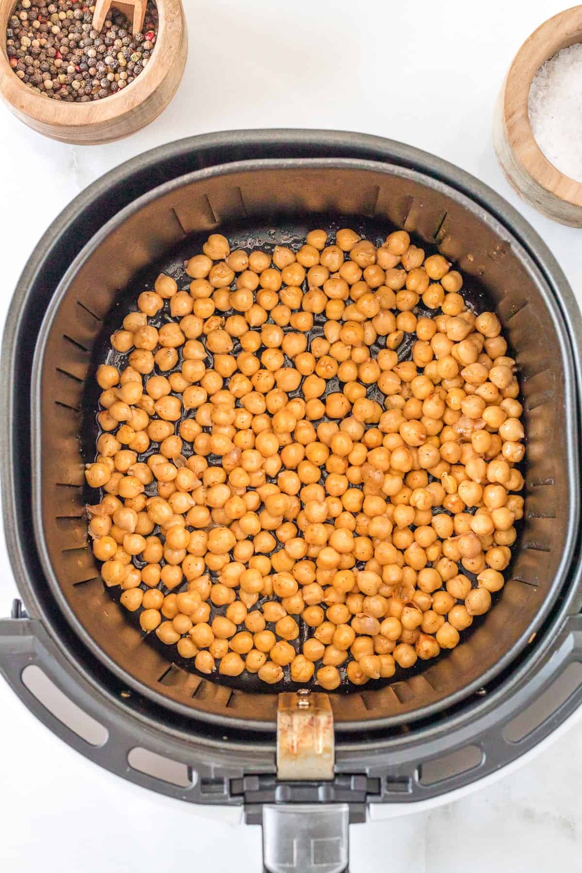 uncooked chickpeas on the basket of the air fryer.