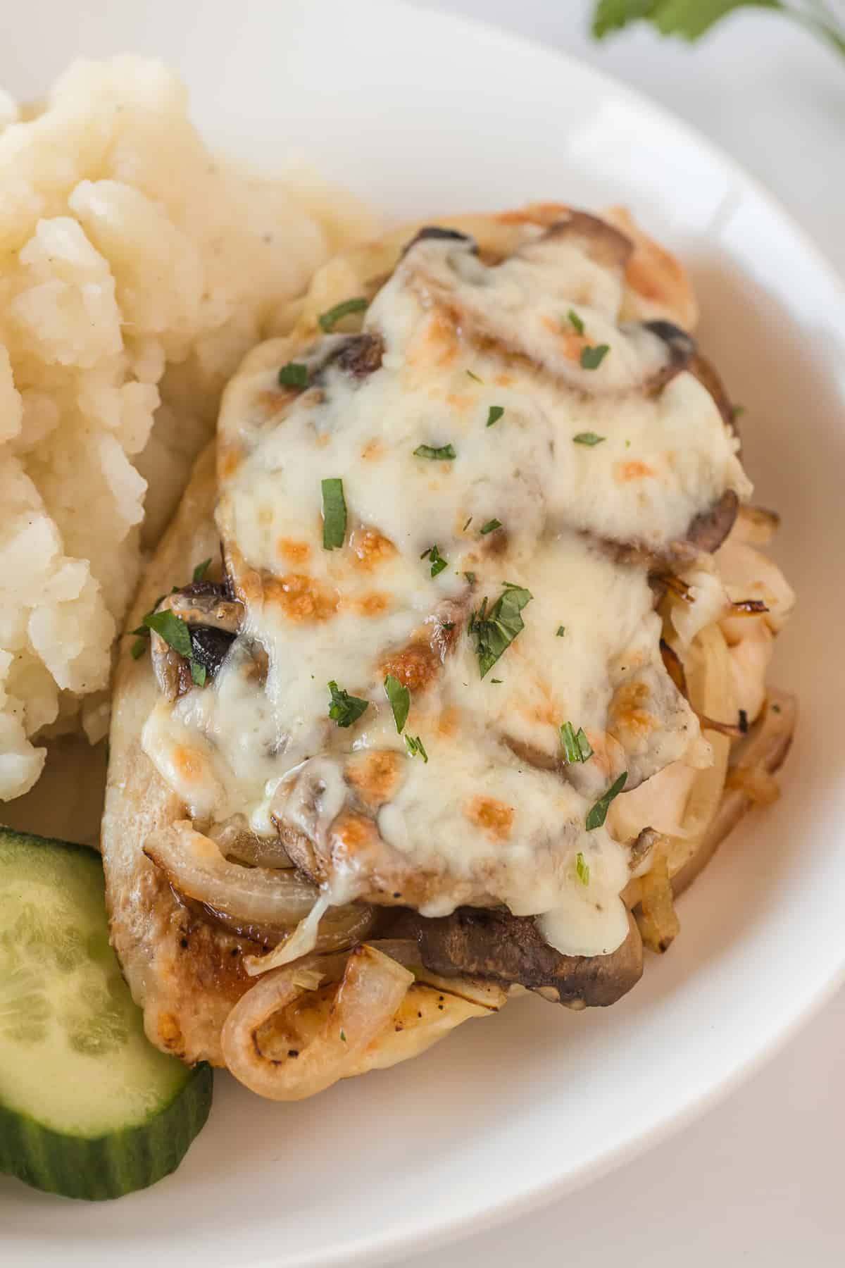 Alice Springs chicken serve in a plate with sliced cucumber and mashed potatoes.