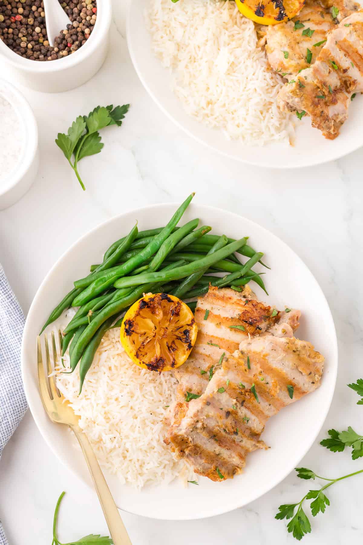 Grilled chicken serve in a plate with rice and green beans.