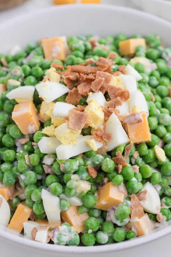 Close up on the peas salad in a white bowl.