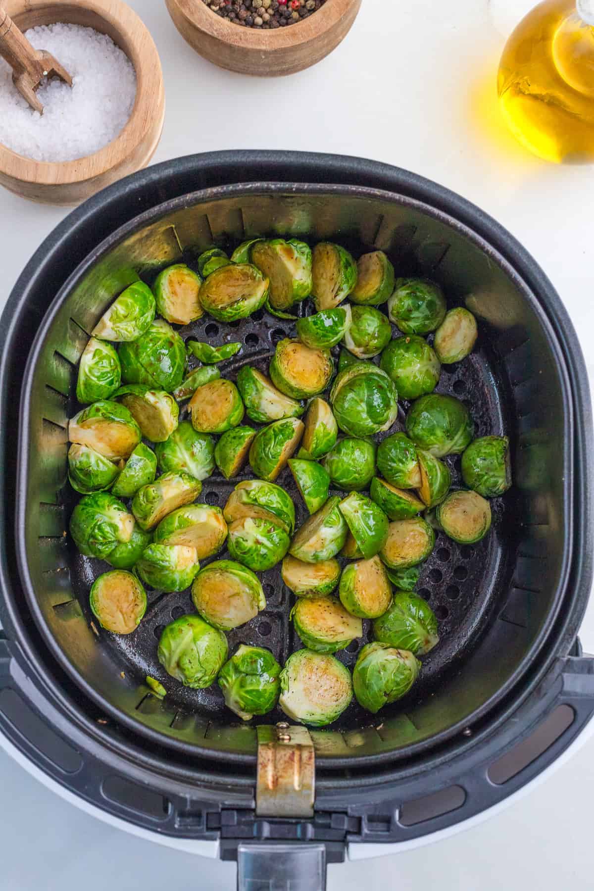 uncooked Brussel sprouts in the basket of the air fryer.
