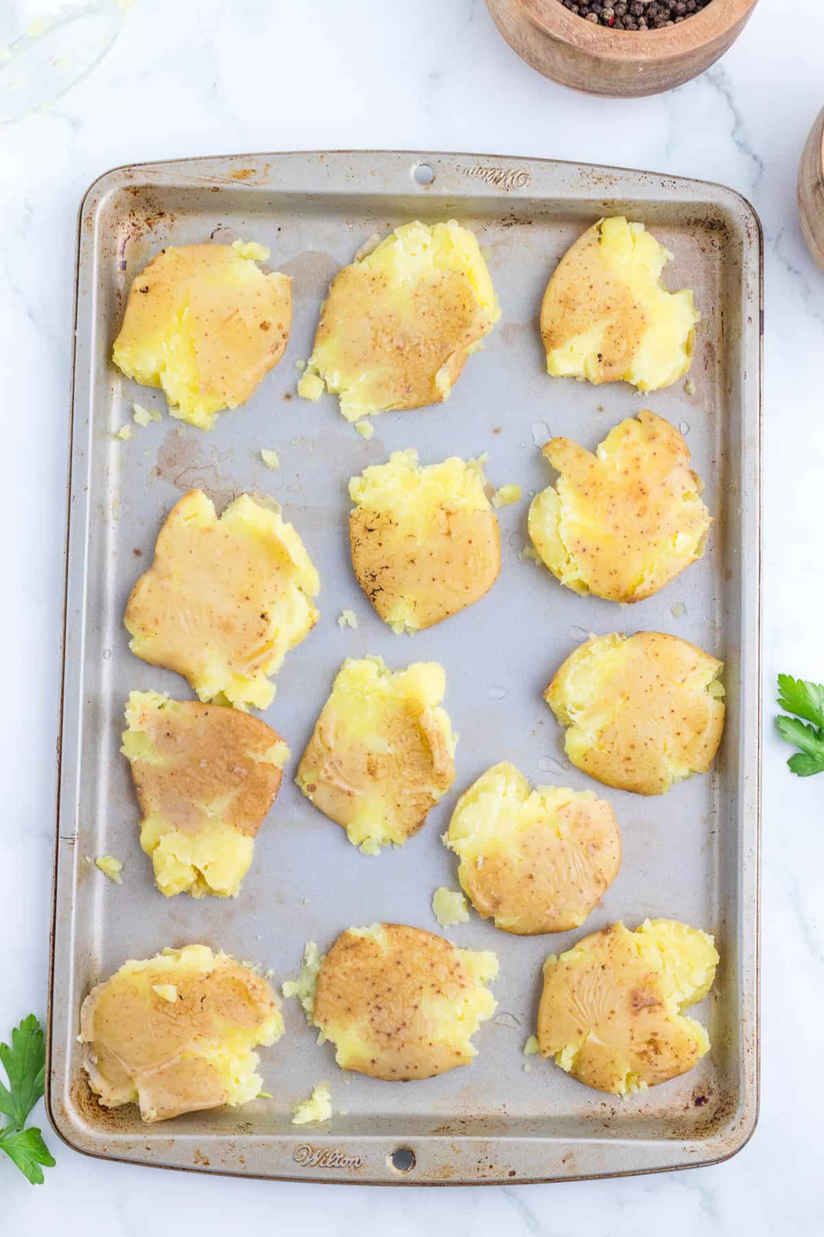 smashed potatoes  on cooking sheet.
