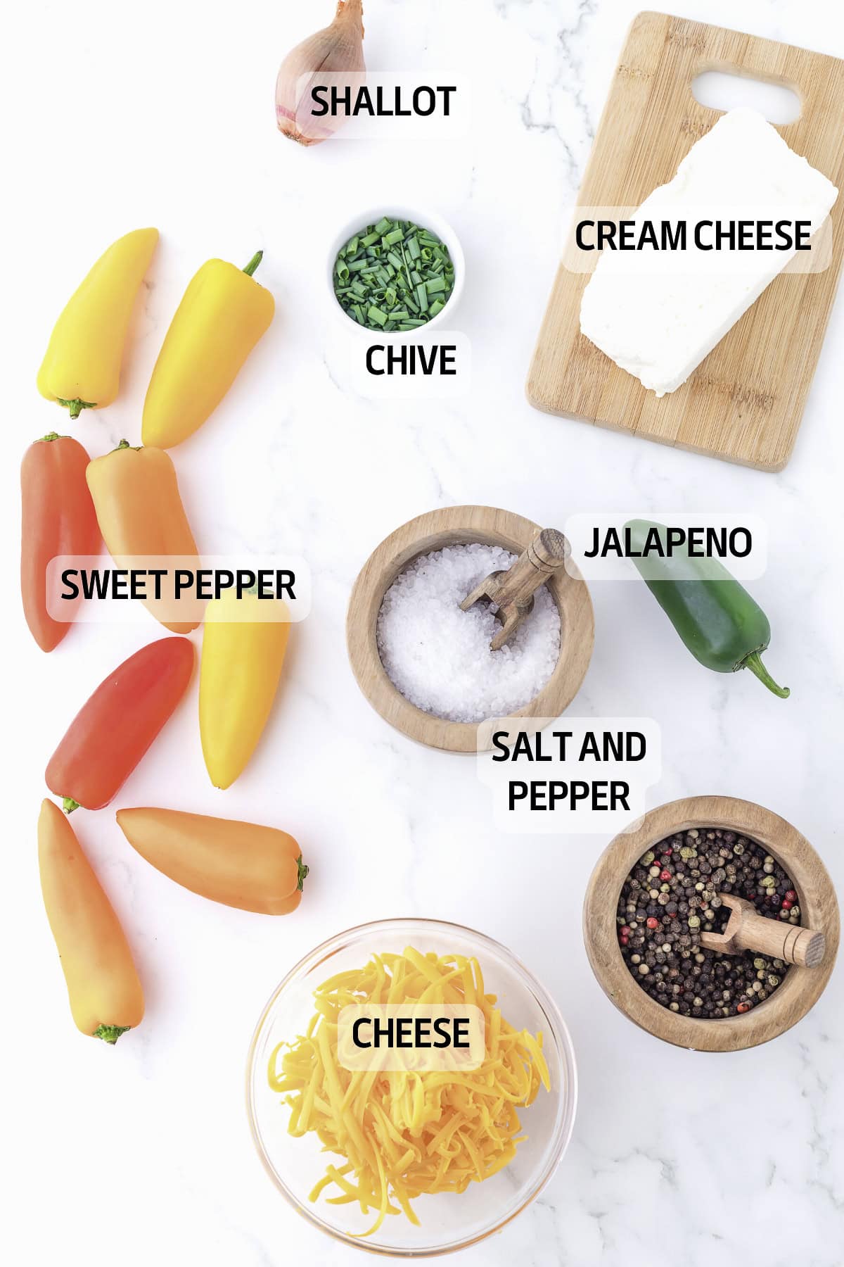Assorted ingredients on a marble surface include shallot, chive, cream cheese, sweet peppers, jalapeno, salt and pepper, and shredded cheese.
