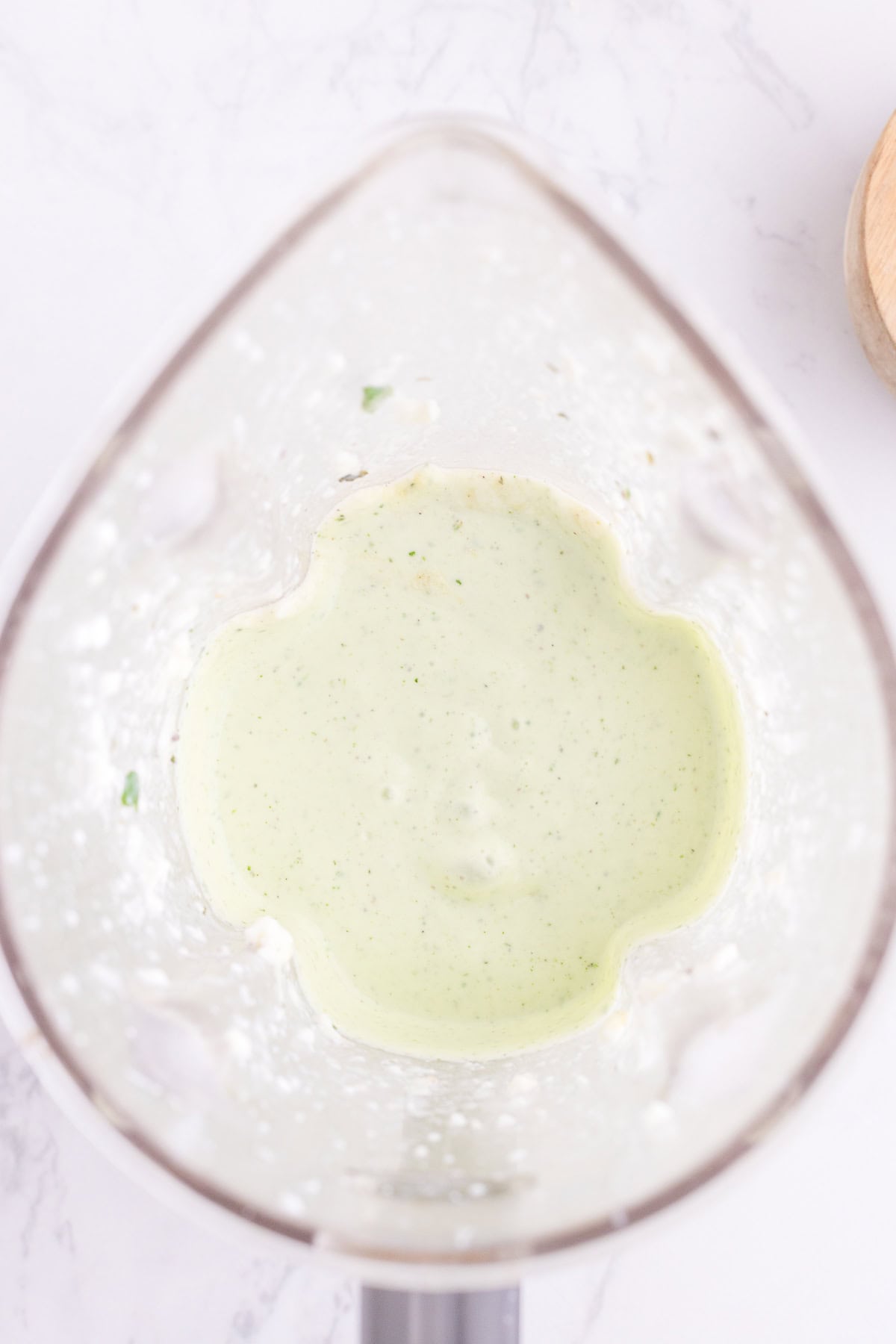 Top view of a blender containing a Cottage cheese ranch dip on a white surface.