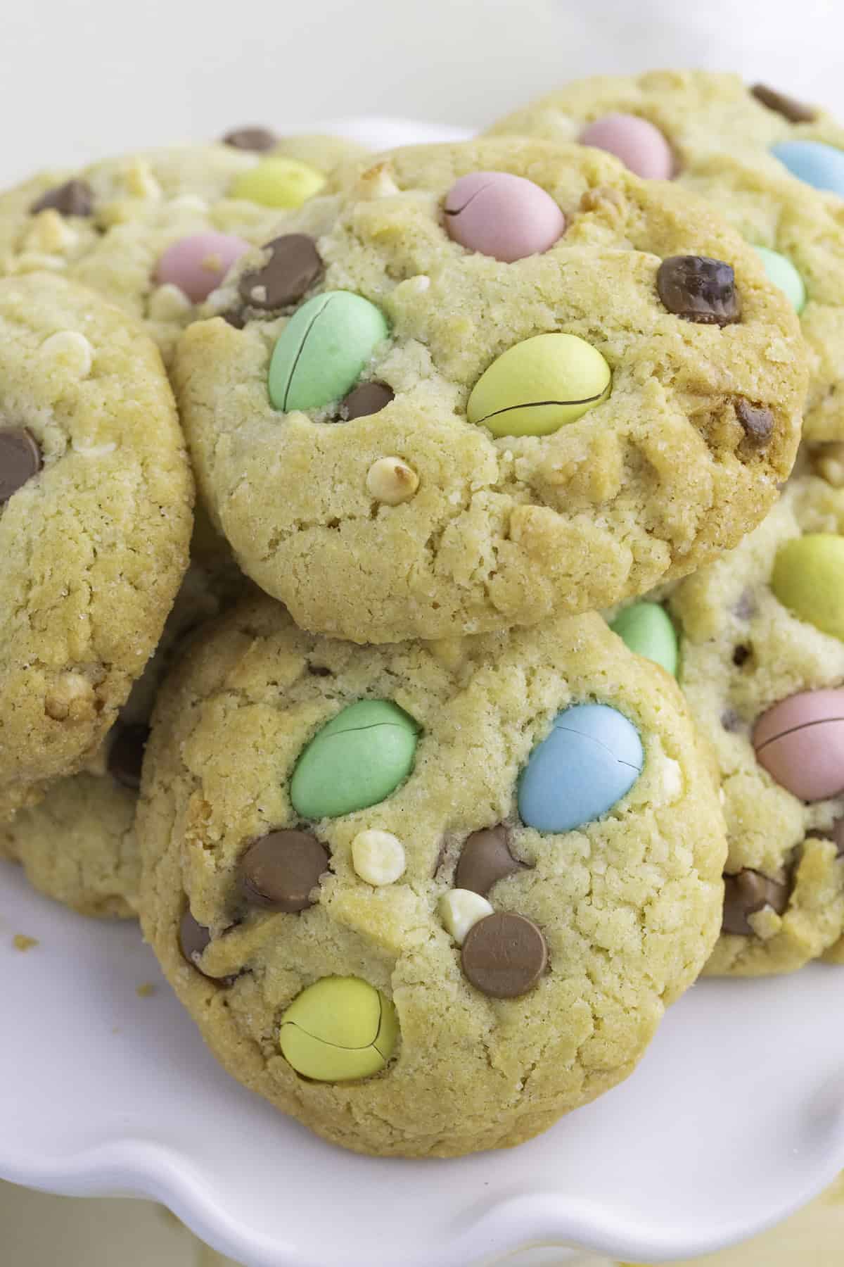 A plate of cookies with colorful candy-coated chocolates and chocolate chips on top.
